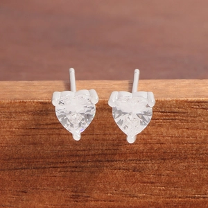 Boucles d'oreilles cœur en argent 925 avec zirconiums sur support en bois naturel