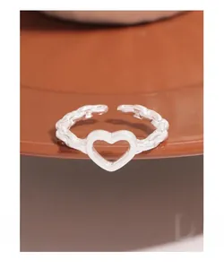 Macro detail of S925 sterling silver chain ring featuring an open hollow heart design