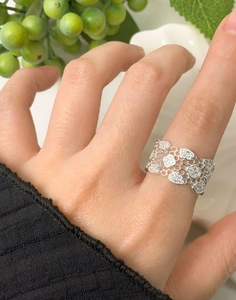 Macro detail of a wide hollow honeycomb silver ring with micro-set zircon stones