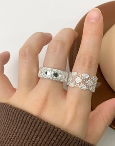 Detailed macro view of S925 silver rings with lace woven texture and hollow honeycomb design