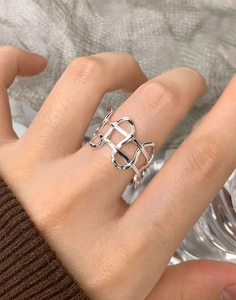 Macro detail of silver S925 irregular woven hollow ring showing polished metal texture