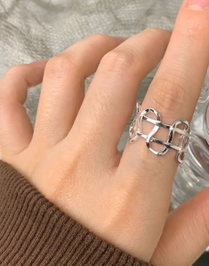 Close-up of S925 sterling silver hollow woven ring on finger with minimalist design