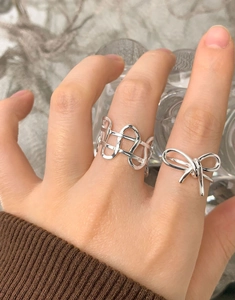 Detail of S925 sterling silver hollow woven wide ring and elegant bow ring set on hand
