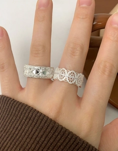 Detail of S925 silver lace ring and woven textured band on model fingers
