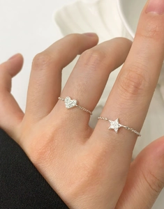 Detail of adjustable S925 silver chain rings with sparkling zircon heart and star charms