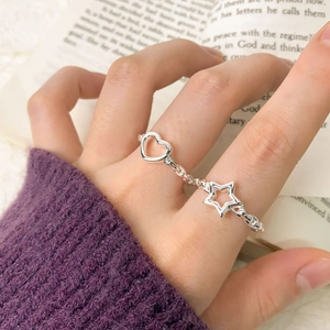 S925 sterling silver hollow heart and star chain ring worn on a finger in macro detail