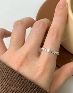 Detail of adjustable S925 sterling silver ring with cubic zirconia on a model's finger