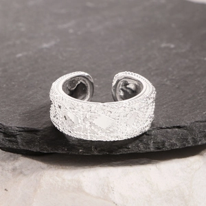 Elegant S925 sterling silver ring with intricate woven lace texture on a dark stone base