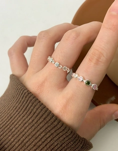 Detail of silver S925 rings with colorful zircons worn on hand for elegant stacking