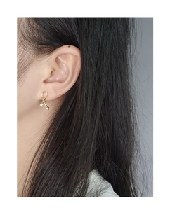 Golden bow pearl earrings with cubic zirconia on model showing actual size and style