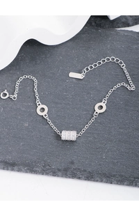 Detail of S925 sterling silver bracelet featuring a zircon cylinder pendant on a stone surface