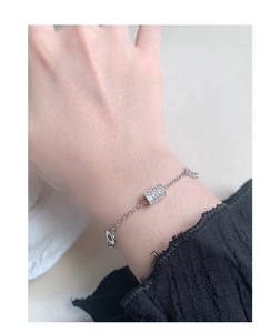 Detail of silver S925 sterling chain bracelet with micro-paved zircon cylinder charm