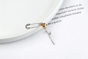 Detail of S925 sterling silver safety pin earring with golden 3D rose flower design