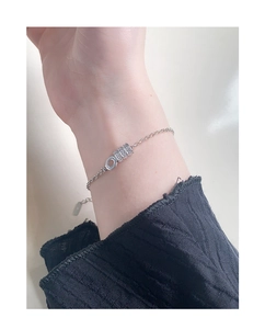 Detail view of a 925 sterling silver chain bracelet with a sparkling zircon cylinder charm