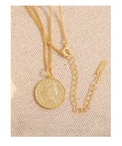 Vue macro d'un collier pièce en argent S925 doré avec gravure de portrait de la reine