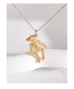 Détail d'un pendentif ours 3D doré avec texture de couture et chaîne en argent fin