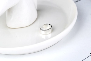 Polished silver s925 cuff earring with minimalist U-shaped design on white tray