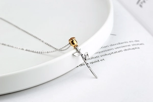 Detailed close-up of S925 silver and gold-plated rose flower pendant on a ceramic tray