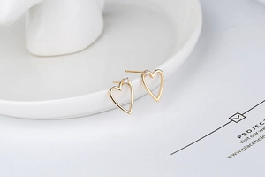 Close-up of S925 sterling silver heart earrings with a single zircon stud detail