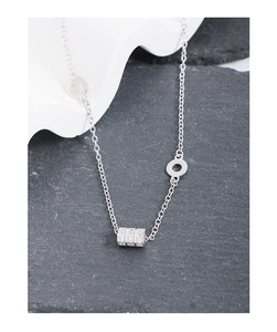 Macro shot of S925 silver cylinder pendant with pavé set zircon on black stone