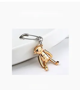 Macro d'une épingle de sûreté en argent S925 avec un pendentif d'ours en peluche doré