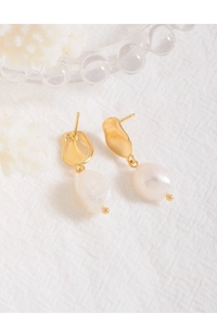 Close-up of S925 silver gold baroque pearl drop earrings on white textured fabric background