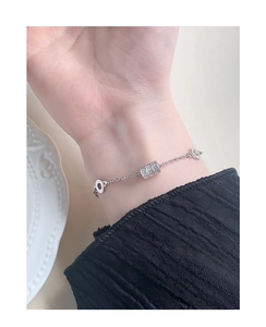 Close-up of minimalist S925 silver bracelet featuring a micro-paved zircon cylinder pendant