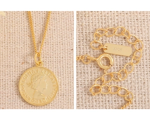 Gros plan du poinçon S925 et du portrait d'Élisabeth II sur un collier de pièces dorées