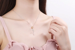 Close-up of elegant gold rose pendant necklace worn by a model on a delicate chain