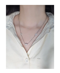 Macro shot of silver S925 necklace featuring a pavé-set cylinder pendant on the neck