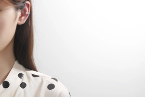 Close-up of minimalist silver S925 ear cuff worn on the cartilage in a modern U-shaped design