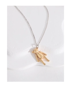 Détail du pendentif ours d'or 3D sur chaîne argentée posé sur une pierre blanche