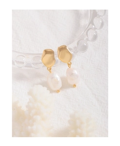 Detailed close-up of baroque pearl earrings with matte gold irregular metal charms