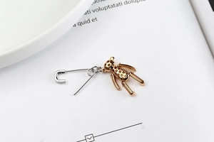 Détail de boucles d'oreilles épingle en argent S925 avec pendentif ours doré