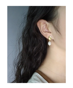 Detailed close-up of a model wearing S925 silver baroque pearl earrings with golden metal