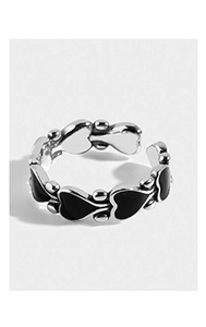 Detail of vintage silver heart ring with black enamel inlay and adjustable open band