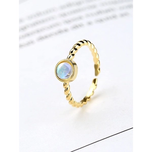 Macro view of gold rope textured ring with iridescent moonstone in a bezel setting