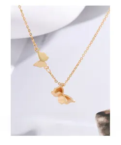 Macro detail of gold butterfly double pendant necklace with delicate O-link chain