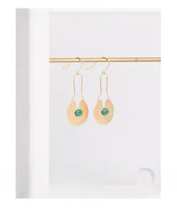 Detail of S925 silver watermelon pattern earrings with malachite stones on a gold stand