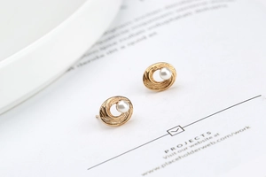 Detailed view of spiral texture and white pearl on gold-plated sterling silver earring