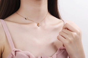 Detail of elegant gold butterfly pendant necklace worn by a model on a delicate chain