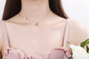 Close-up of elegant gold double butterfly pendant necklace on a delicate chain