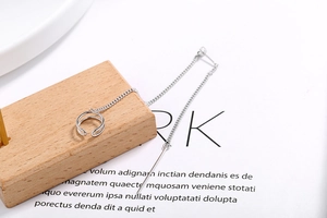 Detail of S925 sterling silver ear line with ear cuff and chain on a wooden base
