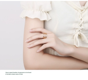 Close-up of elegant gold triple-layer streamline ring worn on model's finger