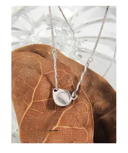 Detail of s925 sterling silver necklace with liquid metal style hammered round pendant