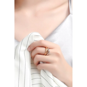 Close-up of minimalist gold and silver wavy S925 rings on a model's finger