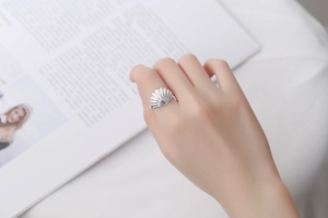 Macro shot of silver seashell S925 ring showing intricate textured detail on finger