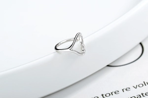 Detailed close-up of a 925 sterling silver heart-shaped adjustable cuff ring on a white plate