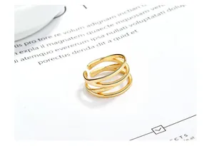 Detailed view of a golden triple-layer interlaced streamline ring on white background