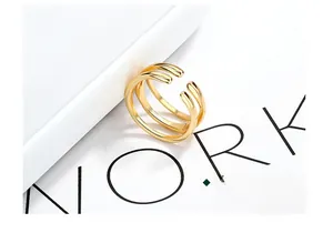Macro detail of minimalist triple-layered gold-plated S925 silver ring on white background